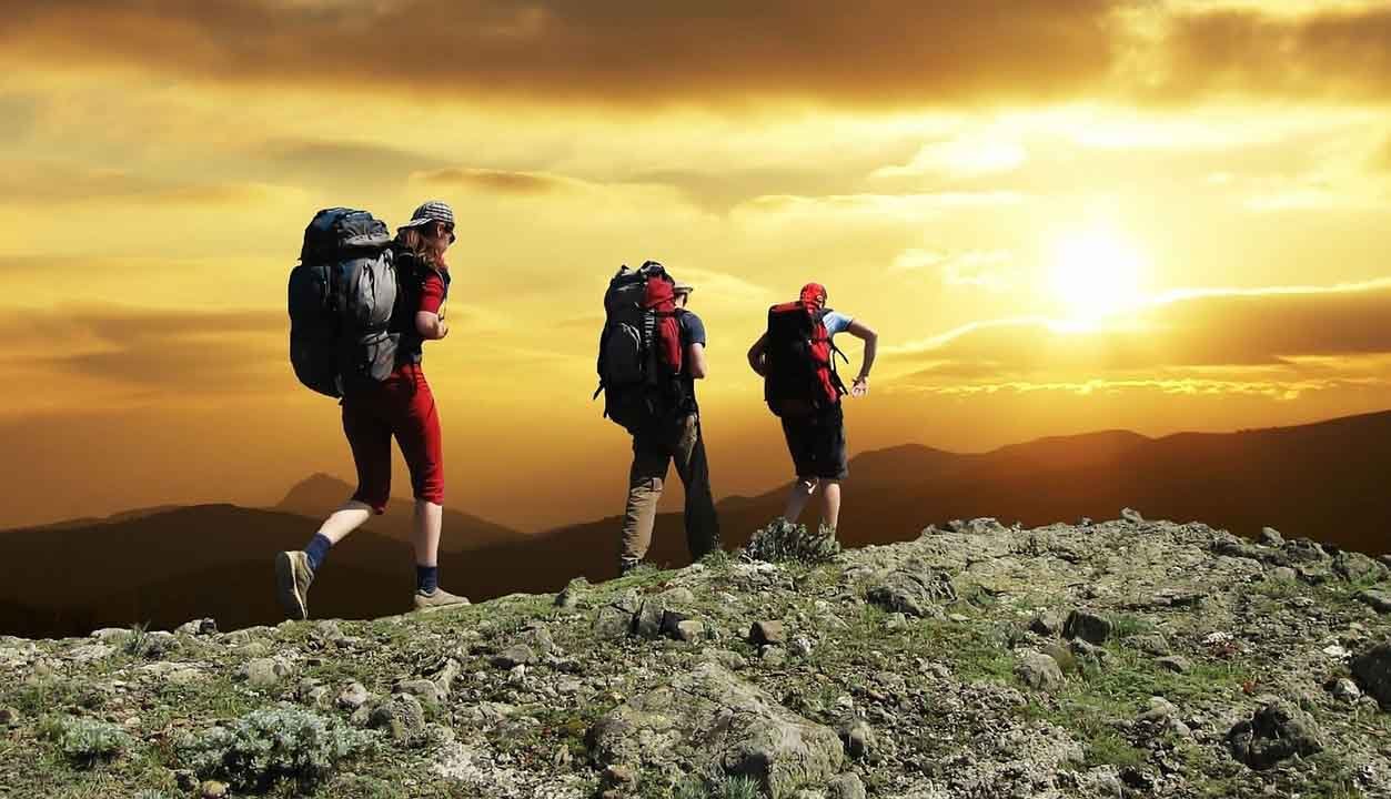 tres personas haciendo trekking en la montaña